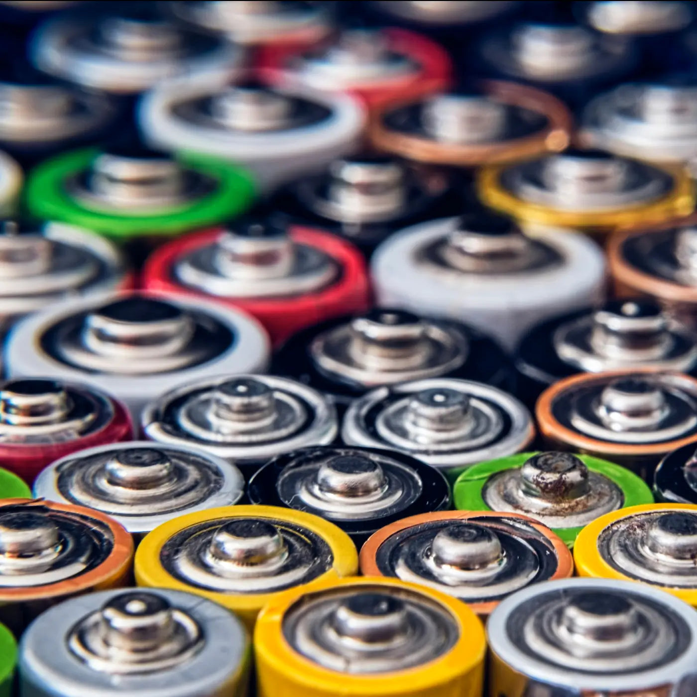 Close-up image of various colourful batteries arranged closely together